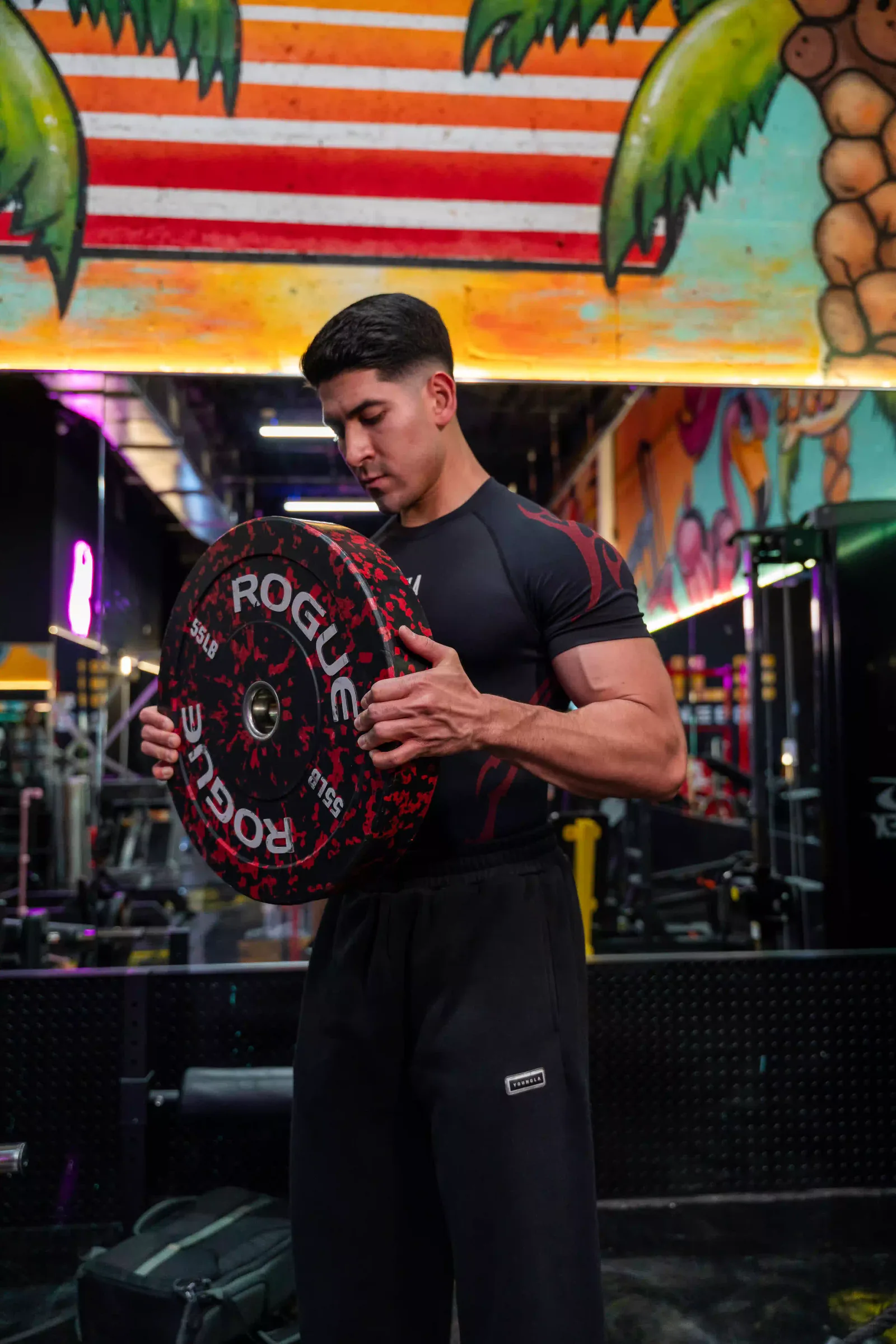 Juan Wagner sosteniendo un disco de peso en el gimnasio